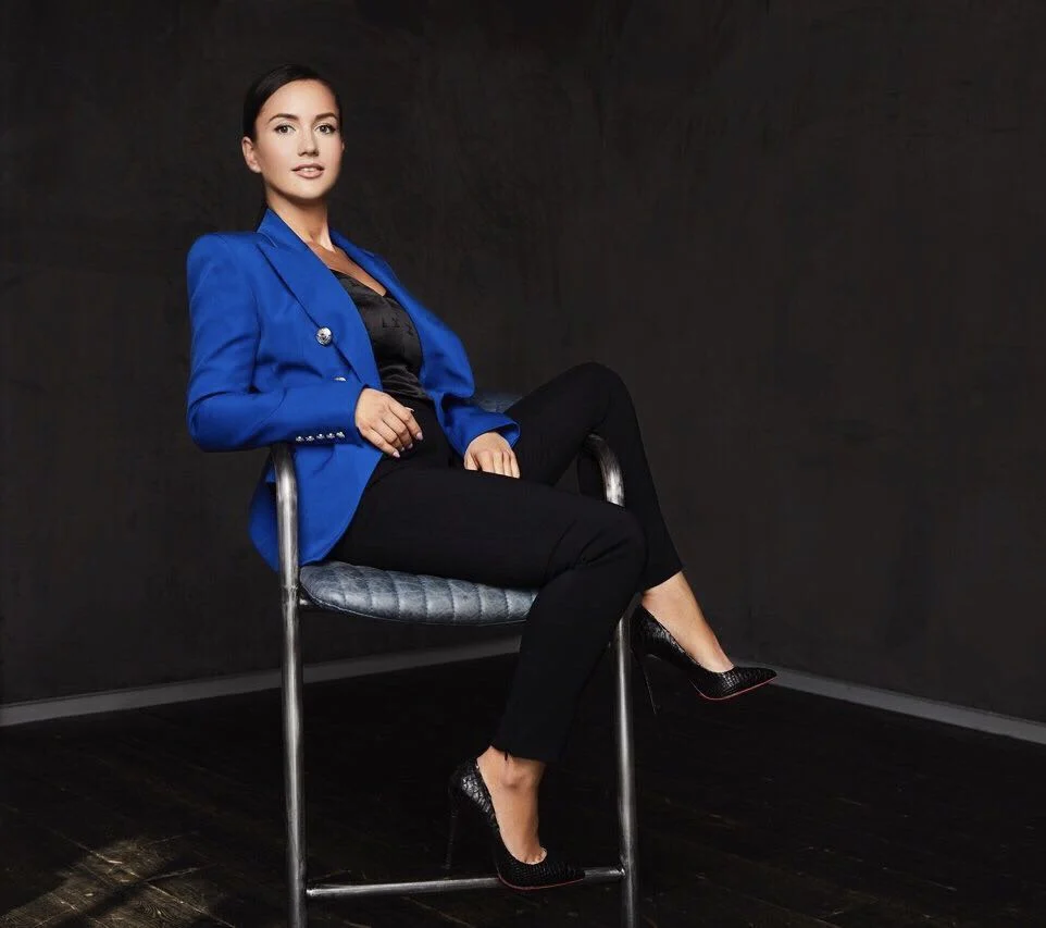 Lisa Smith seated in a blue tailored blazer and black trousers